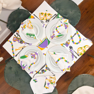 Mardi Gras-themed tablecloth and decorations on a dining table.