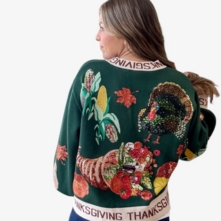 Green Thanksgiving sweater with turkey and cornucopia design on a white background