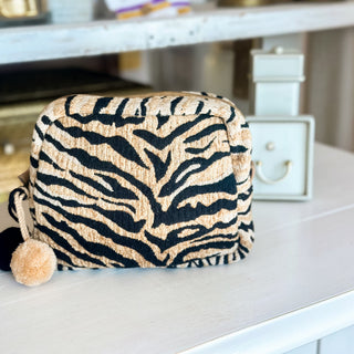 Tiger print makeup bag in tan and black with pom pom zipper accents, matching cosmetic pouch included with tiger duffle bag