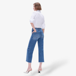 Woman wearing blue jeans and a white shirt on a white background