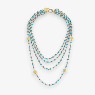 Multistrand necklace with turquoise beads and gold accents on a white background