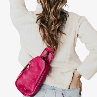 Fuchsia pink sling bag worn crossbody with adjustable strap and zipper pocket stylish everyday hands free crossbody bag.