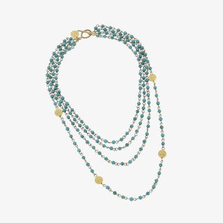 Stack of blue beaded necklaces with gold accents on a white background