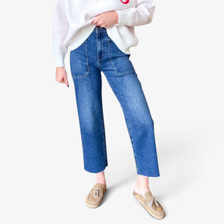 Utility wide leg jeans in dark blue denim featuring high rise waist, oversized front patch pockets and cropped raw hems, front detail view.