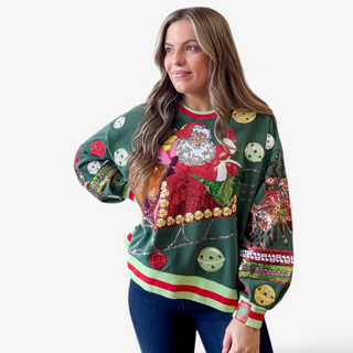 Woman wearing a festive green sweater with colorful patterns on a white background