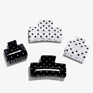 Polka dot hair claw clips in black and pearl white, shown in small and standard sizes on a white background