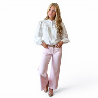 White pintuck cotton blouse with lace inset detailing and long puff sleeves styled with pink pants, front view.