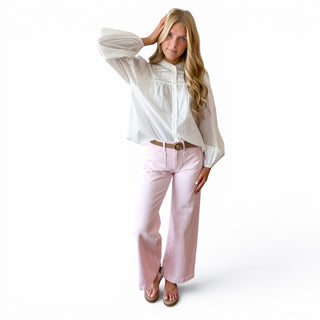 White pintuck cotton blouse with button front and feminine lace details styled with pink wide leg pants, full-length front view.
