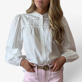 White pintuck cotton blouse close-up showing the lace-trim pintuck yoke, button front and gathered long sleeves, detail view