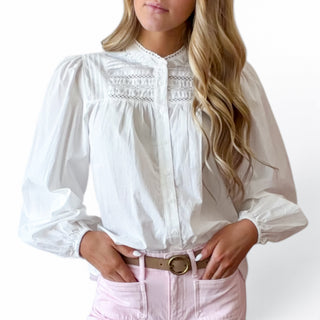 White pintuck cotton blouse featuring lace trim, pintuck detailing and covered button front, close-up detail view.