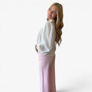 White pintuck cotton blouse with a relaxed silhouette and gathered balloon sleeves styled with pink jeans, side view
