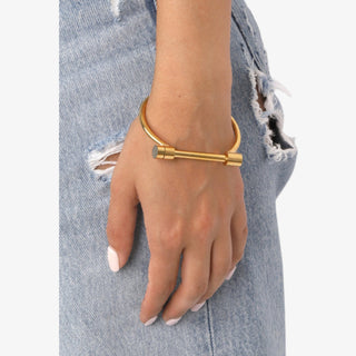 Hamlin Gold Bracelet with polished bar detail, modern cuff bangle design worn on wrist with casual denim.
