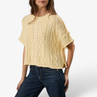 Butter yellow cable knit short sleeve sweater for women shown in a relaxed-fit view with a roomy boxy silhouette and side slit hem.
