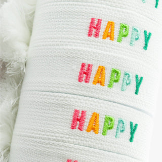 Tie Happy white fabric bracelets with colorful embroidered HAPPY lettering, close-up product detail view
